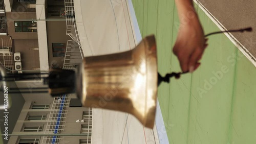 Cycling referee rings bell on velodrome. Open cycling track. Vertical video photo