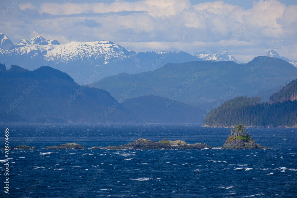 Panoramic morning or day time landscape nature coastal scenery with beautiful blue sky and dramatic cloudscapes in Alaska Inside Passage glacier mountain range view during cruise