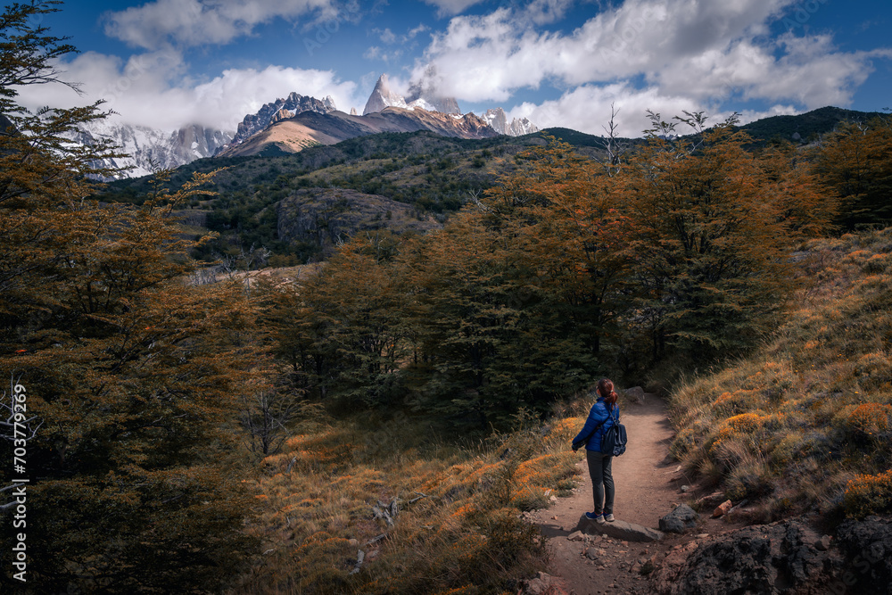 A woman with blue cloth looking at to the Mt.Fitz roy with beautiful clouds and sky  (Patagonia, El chalten, Argentina)