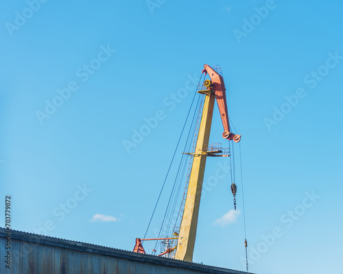 boom shipbuilding cranes on a background of blue sky, natural light.