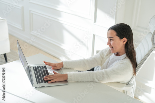Online Fun. Smiling Middle Eastern Preteen Girl Using Laptop Computer  Relaxing Playing Games And Enjoying Web Entertainment At Home. Digital Weekend Leisure Concept