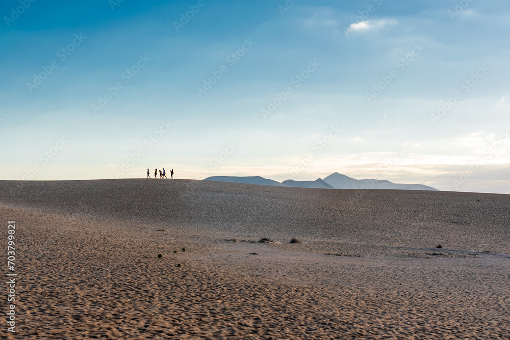Silhouettes of people on sand dunes on Fuerteventura
