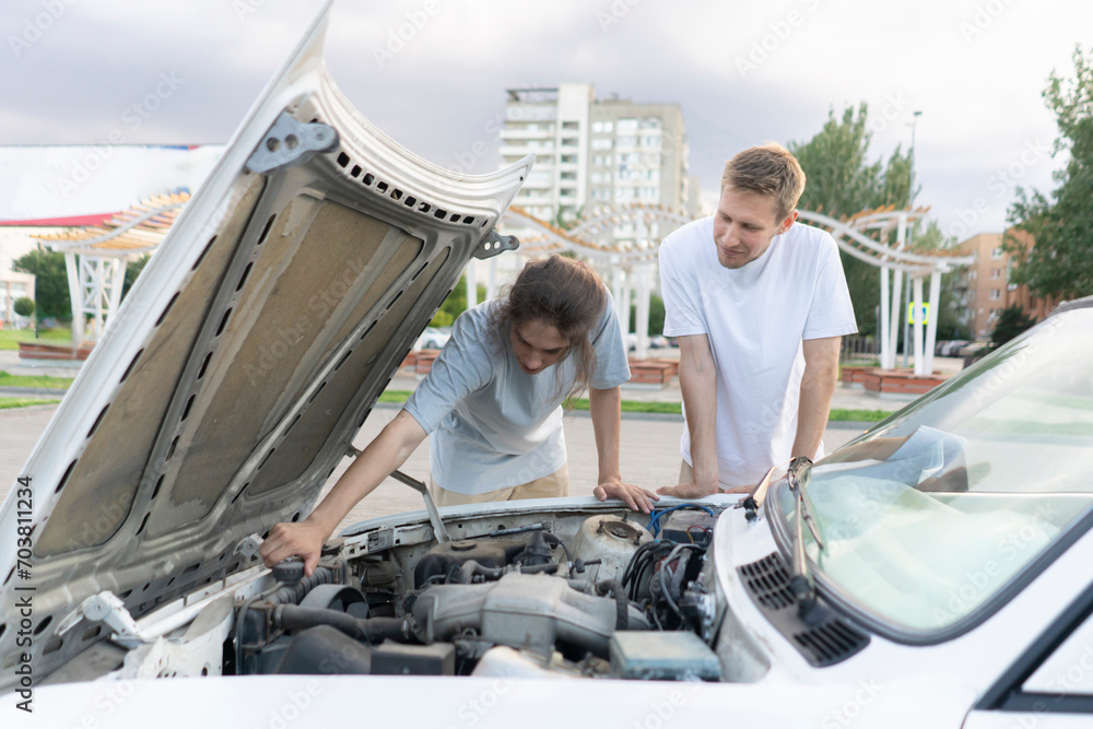 Car Troubles: Two Men Inspecting Engine Under Hood on Highway Car Troubles: Two Men Inspecting Engine Under Hood on Highway
