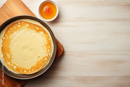 one thin pancake on a plate with a cup of honey for breakfast. view from above. copy space