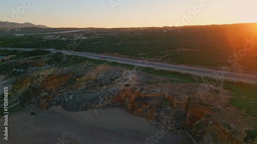 Drone shot picturesque road on beautiful nature at sunset. Car standing roadway