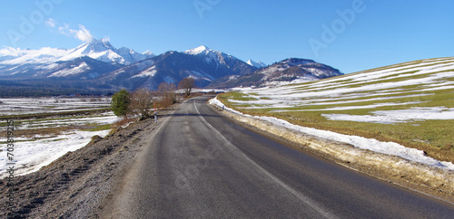 Widok na Tatry ośnieżone, droga asfaltowa, oblodzenia, trudne warunki drogowe.