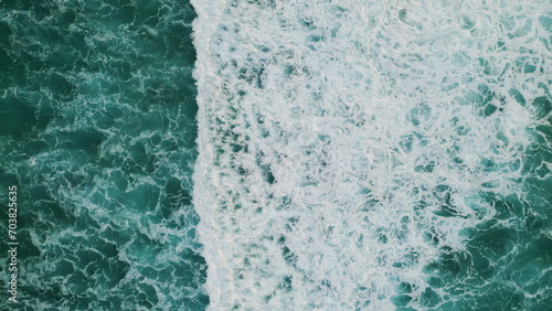 Turquoise water washing seashore aerial view. Marine landscape with foamy waves. © stockbusters