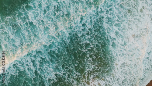 Aerial view calm waves splashing on sand shoreline making white foam. Sea swell 