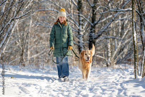 Girl Walks With Golden Retriever In Winter Forest, Strolling With Dog Through Snow-Covered Woods