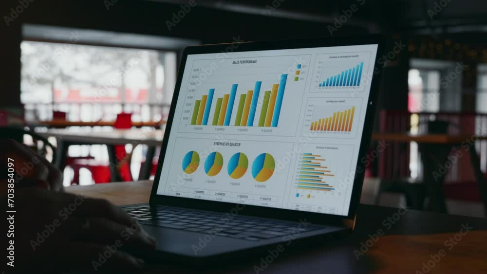 A close-up view of a laptop in a dark room, which opens and an image of graphs with company statistics turns on on the display or screen. Summarizing the results of the year using statistics on charts A close-up view of a laptop in a dark room, which opens and an image of graphs with company statistics turns on on the display or screen. Summarizing the results of the year using statistics on charts