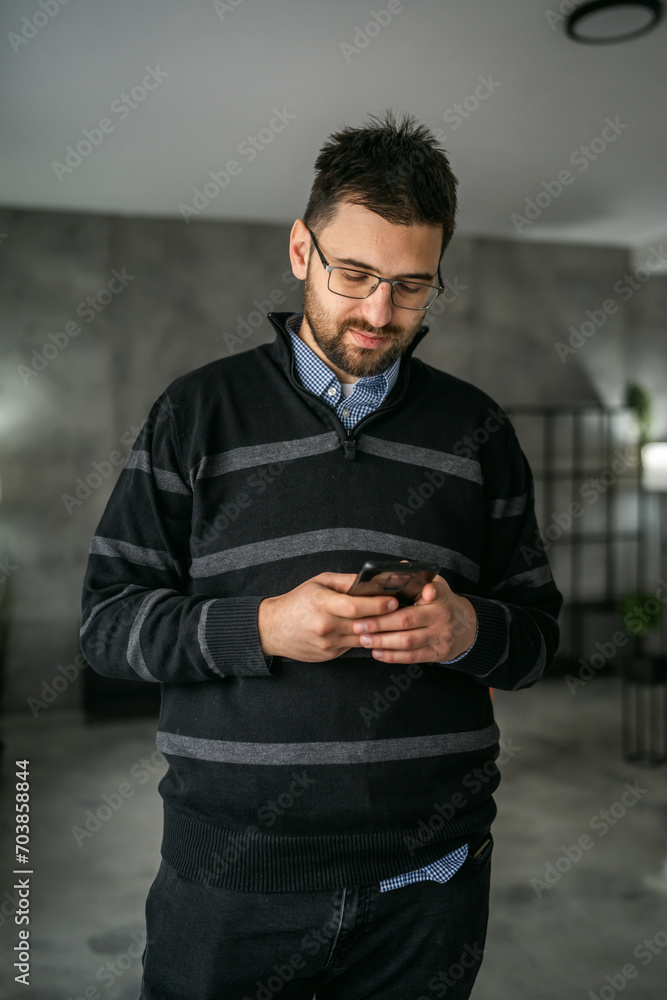 Adult man use mobile phone smartphone at home browse internet or send text messages sms texting Adult man use mobile phone smartphone at home browse internet or send text messages sms texting