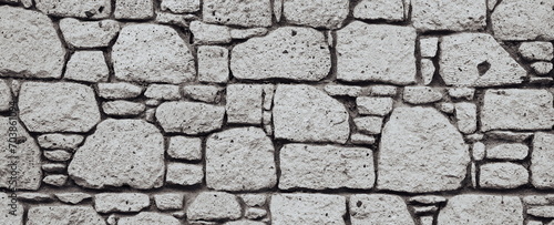 Antique Block Wall. Obsolete Worn Vintage Stone Wall Ancient Texture Grunge background Monochrome Wide Horizontal Photo