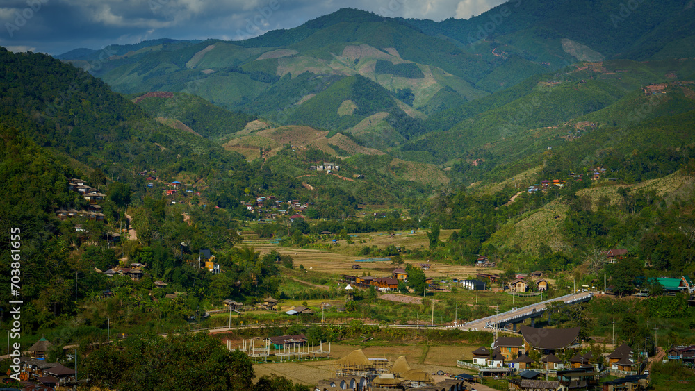 View of many mountains cascading over one another and a small village community distributed in the area below