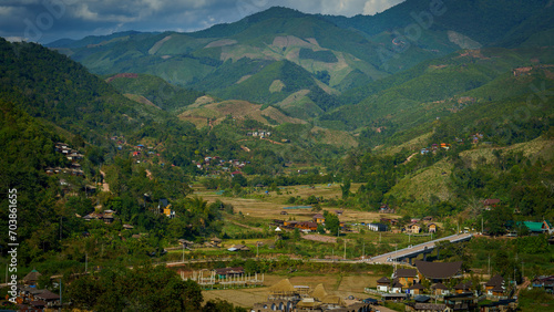 View of many mountains cascading over one another and a small village community distributed in the area below