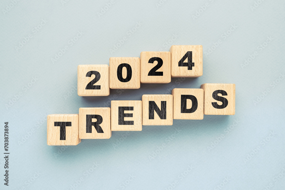 2024 TRENDS, text by wooden cubes arranged on blue paper background 2024 TRENDS, text by wooden cubes arranged on blue paper background