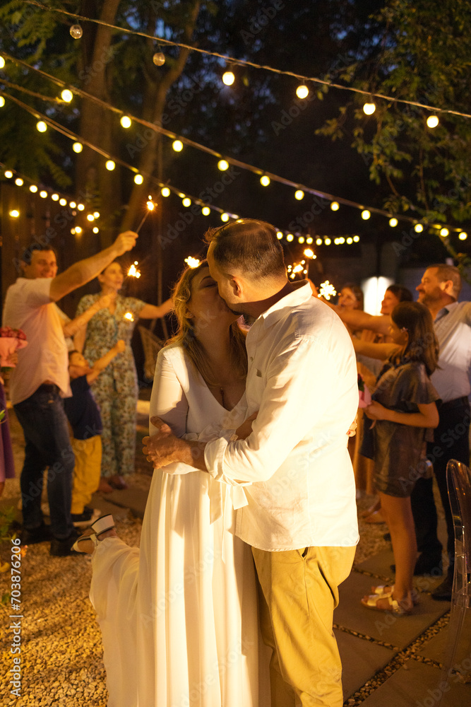 Groom, bride and wedding guests with burning Bengal lights outdoors Groom, bride and wedding guests with burning Bengal lights outdoors