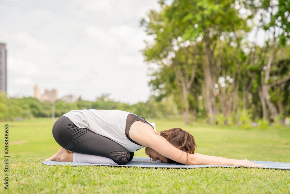 Young women have a beautiful bodies, Playing yoga in an elegant posture, in the green park, is a concept of people's recreation and health care concept. blurred background Young women have a beautiful bodies, Playing yoga in an elegant posture, in the green park, is a concept of people's recreation and health care concept. blurred background