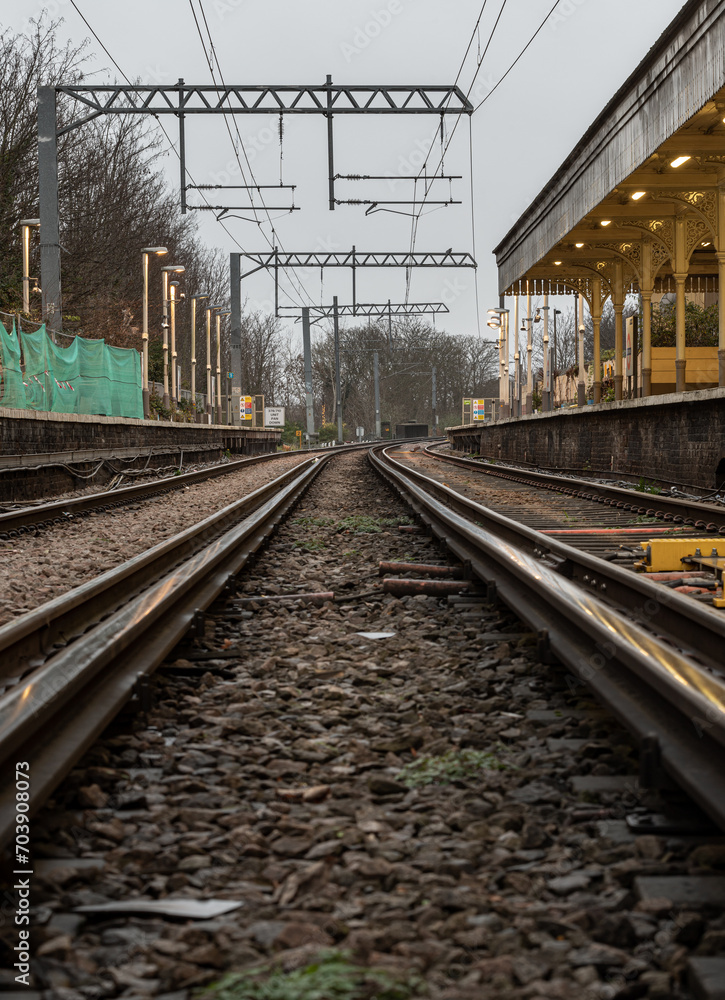 Obraz premium Railway iron rails from the low perspective. Railroad tracks with limited depth of focus, The Railway system with Metal frames of Train platform, Railroad track rails, Train tracks, Railway station, S