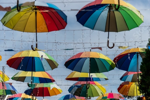 multicolored umbrellas hang from the ceiling of a market