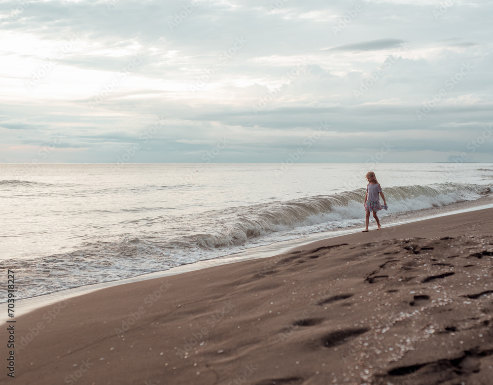 A girl walks along the sandy beach. Sea coast. A girl walks along the sandy beach. Sea coast.