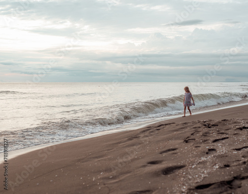 A girl walks along the sandy beach. Sea coast.