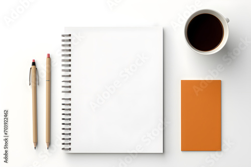 Pencil, blank notebook, coffee and miscellaneous items on the desk