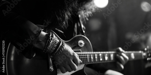 Amusician playing the guitar. Musical performance. High contrast black and white. Moody. Shallow depth of field.