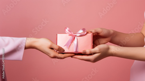 Woman gives a gift to another Woman on a pink background