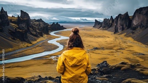Young woman tourist in a yellow coat Iceland landscapes in the background