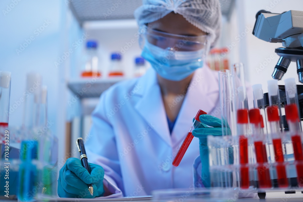 Fototapeta premium Science test tubes, laboratory equipment for new medical research, microbiology research with small pipettes in close-up. Asian and African female scientists in the laboratory, perfume samples