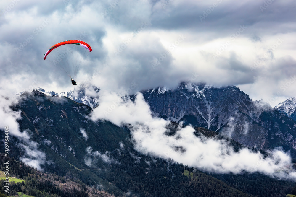 Paragliding in the Stubai Alps under cloudy skies Paragliding in the Stubai Alps under cloudy skies