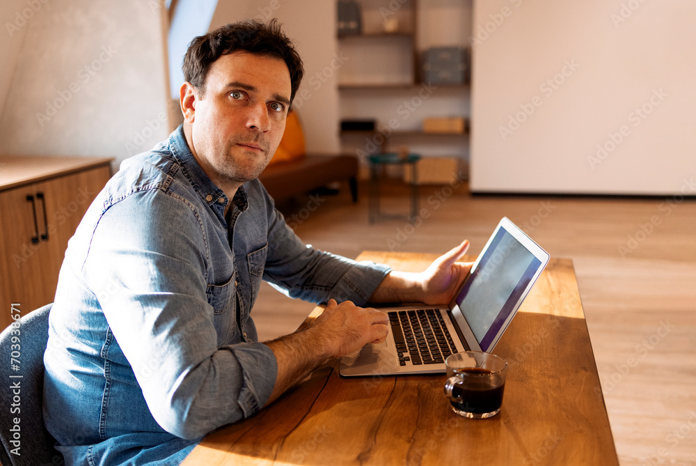 Smiling bearded caucasian businessman working on laptop at home office