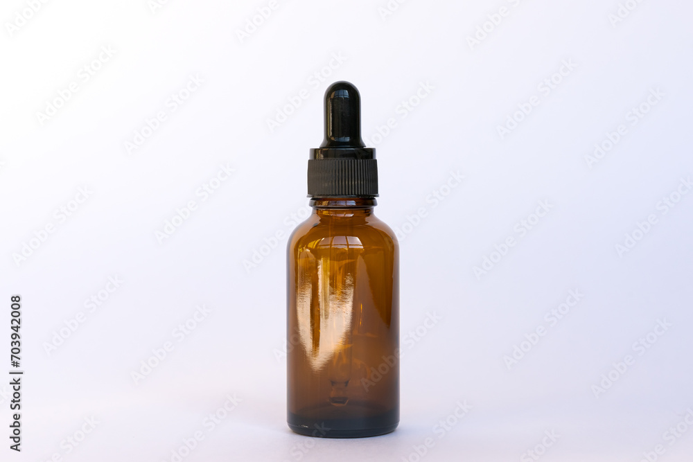 Amber glass cosmetics bottle with dropper, white background. Natural skin care SPA beauty product product design.