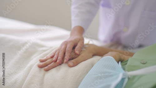 Close up hands of doctor hold patient hand to encourage or hearten to fight with the disease and patient lie on bed in hospital. photo