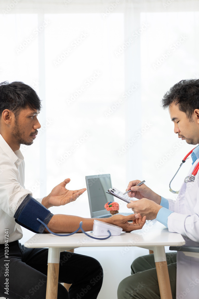 Obraz premium Asian male doctor talking with male patient in office Focus on the brain simulator on the table health care concept