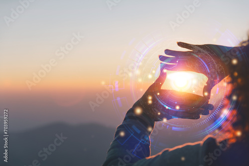 Commercial strategy, planning, and notion of vision. Stunning sunrise in the mountains with a close-up of a young woman making a framing gesture. A woman shooting the dawn photo