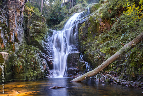 Fototapeta Naklejka Na Ścianę i Meble -  A beautiful waterfall called: kamienczyk shot from close up,with a log in the water. Shot in the mountains of a city named szklarska poreba in poland