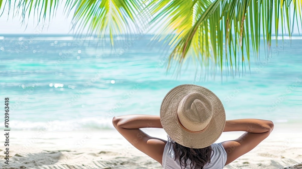 Fototapeta premium Rear view of a woman under a palm tree