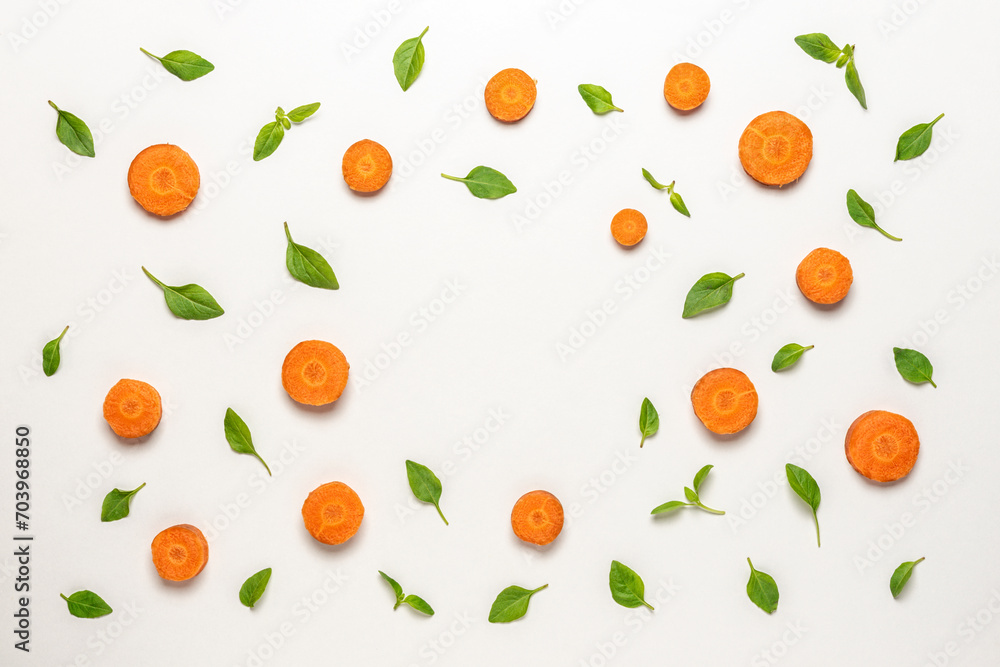 Colorful pattern made of sliced carrots and basil green leaves. Minimal food concept. Colorful pattern made of sliced carrots and basil green leaves. Minimal food concept.