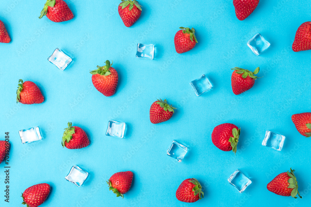 Colorful pattern made of strawberries with ice cubes on blue background. Minimal summer concept. Colorful pattern made of strawberries with ice cubes on blue background. Minimal summer concept.