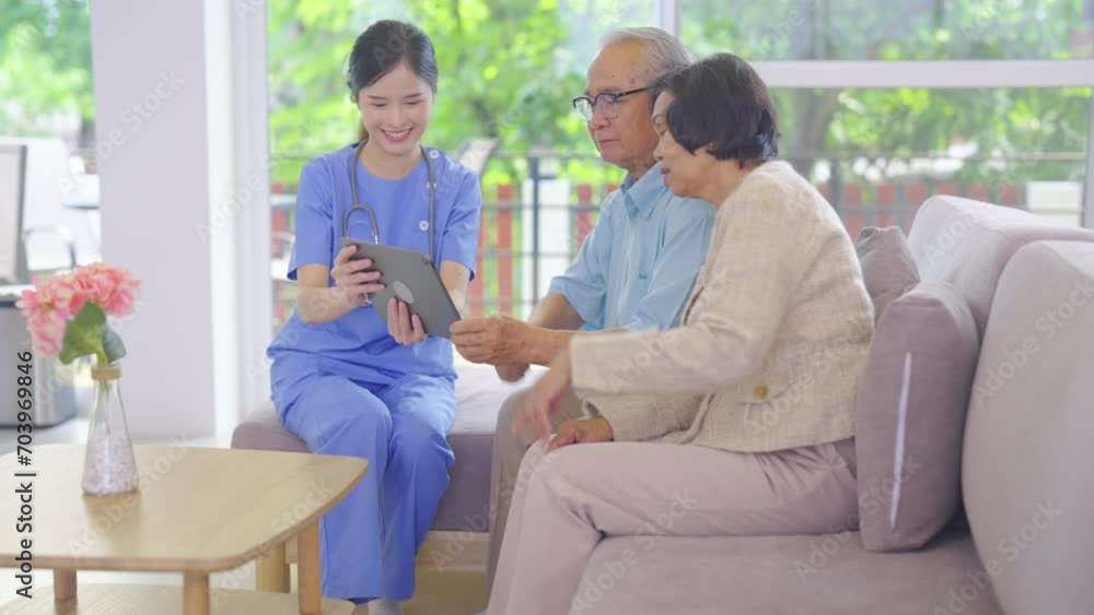 Side view of beautiful Asian nurse or doctor use tablet to consult and give assistant to couple senior man and woman in living room of clinic or hospital in senior healthcare center. Side view of beautiful Asian nurse or doctor use tablet to consult and give assistant to couple senior man and woman in living room of clinic or hospital in senior healthcare center.