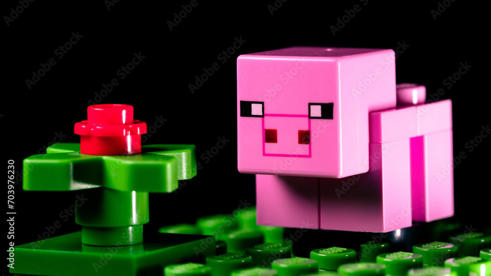 Obraz premium LEGO Minecraft pig on a green meadow next to a red flower
