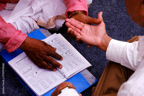 Foto Pune, Maharashtra, India, Palmistry (Palm) Reading, Hast Rekha Reading, A person knowing his future by showing the hand lines on his hand from a Astrologer