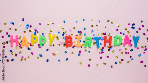 Colorful celebration background with various party confetti and candle decoration. Minimal birthday concept. Flat lay.