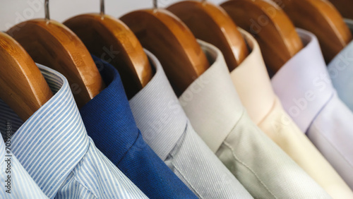 Men's shirts hang on hangers in the store, men's clothing for the office concept background