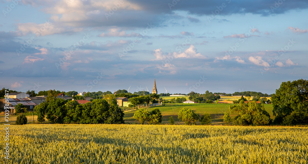Campagne et village avec son clocher au milieu des champs en France.
