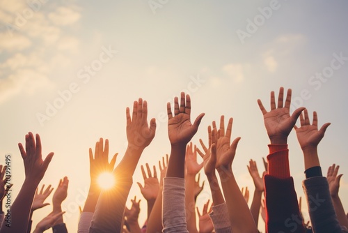 People of different ethnicities raising their hands in the air photo