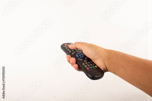 a man's hand holds a remote