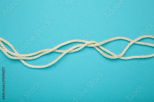 White wavy rope on blue background. Space for text