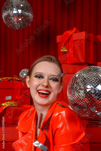 Obraz na płótnie Beautiful girl in shiny red patent leather jacket at a red festive location. Photo shoot in the studio, celebration w salonie